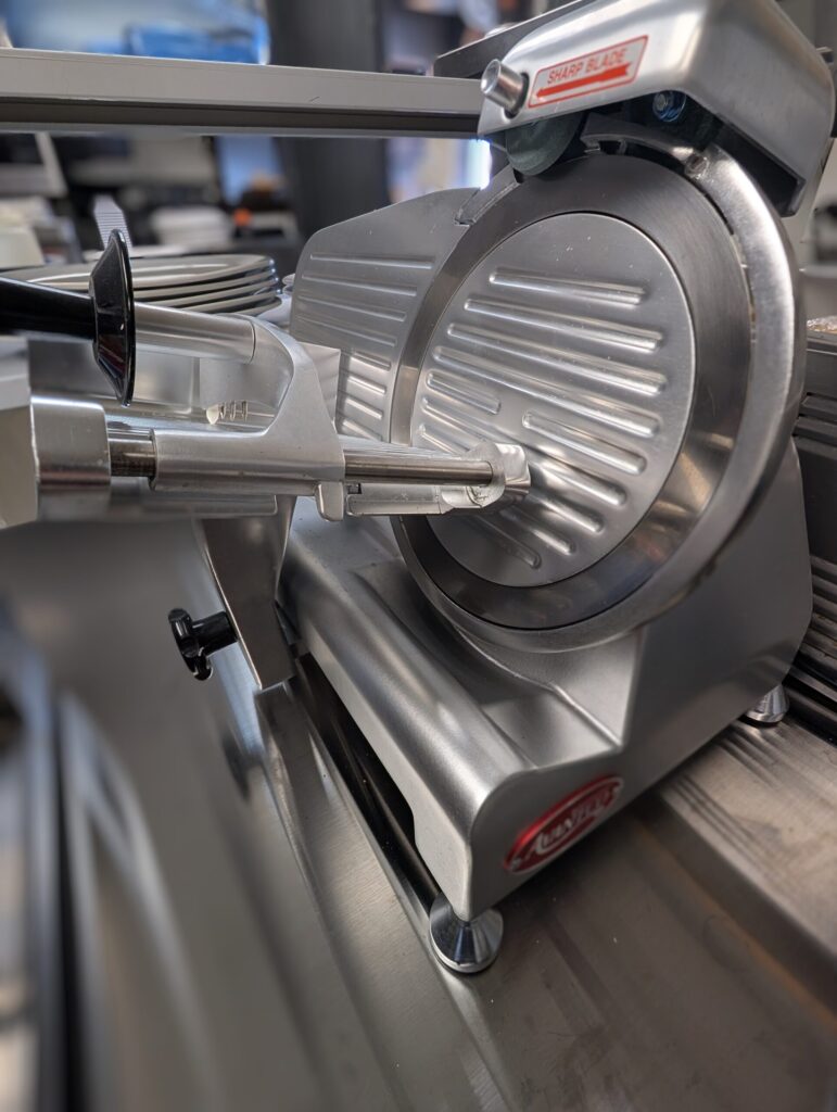 Image of a meat slicer used at the kitchen of our family friendly restaurant, Fish Hawk's of Dewey Beach